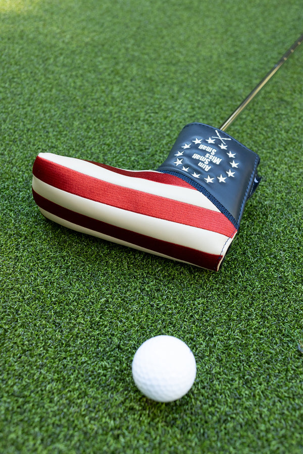 "Aim Small Miss Small" blade putter cover by Tall Pines Golf, on the grass